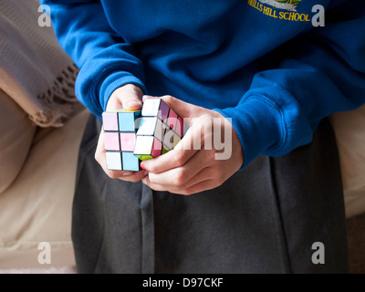 Young girl trying to solve the Rubik`s cube, England, UK. Stock Photo